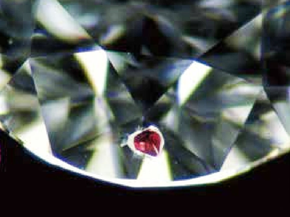 赤いガーネットの原石がダイヤモンドに入り込んでしまったところ