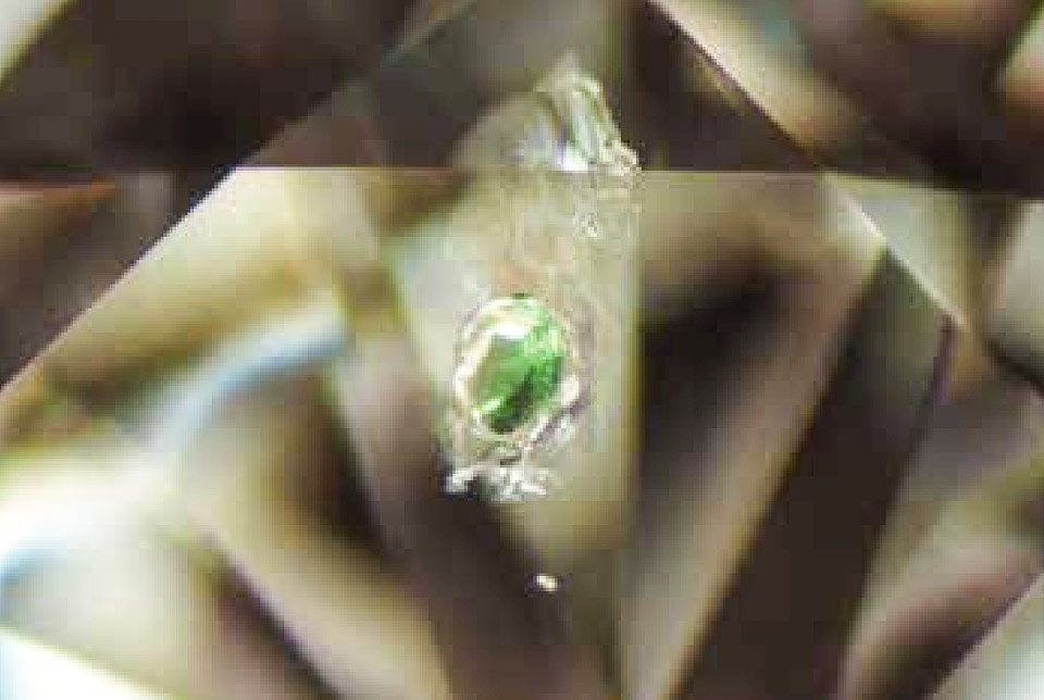 クロムダイオプサイトの原石がダイヤモンドに入り込んでしまったところ